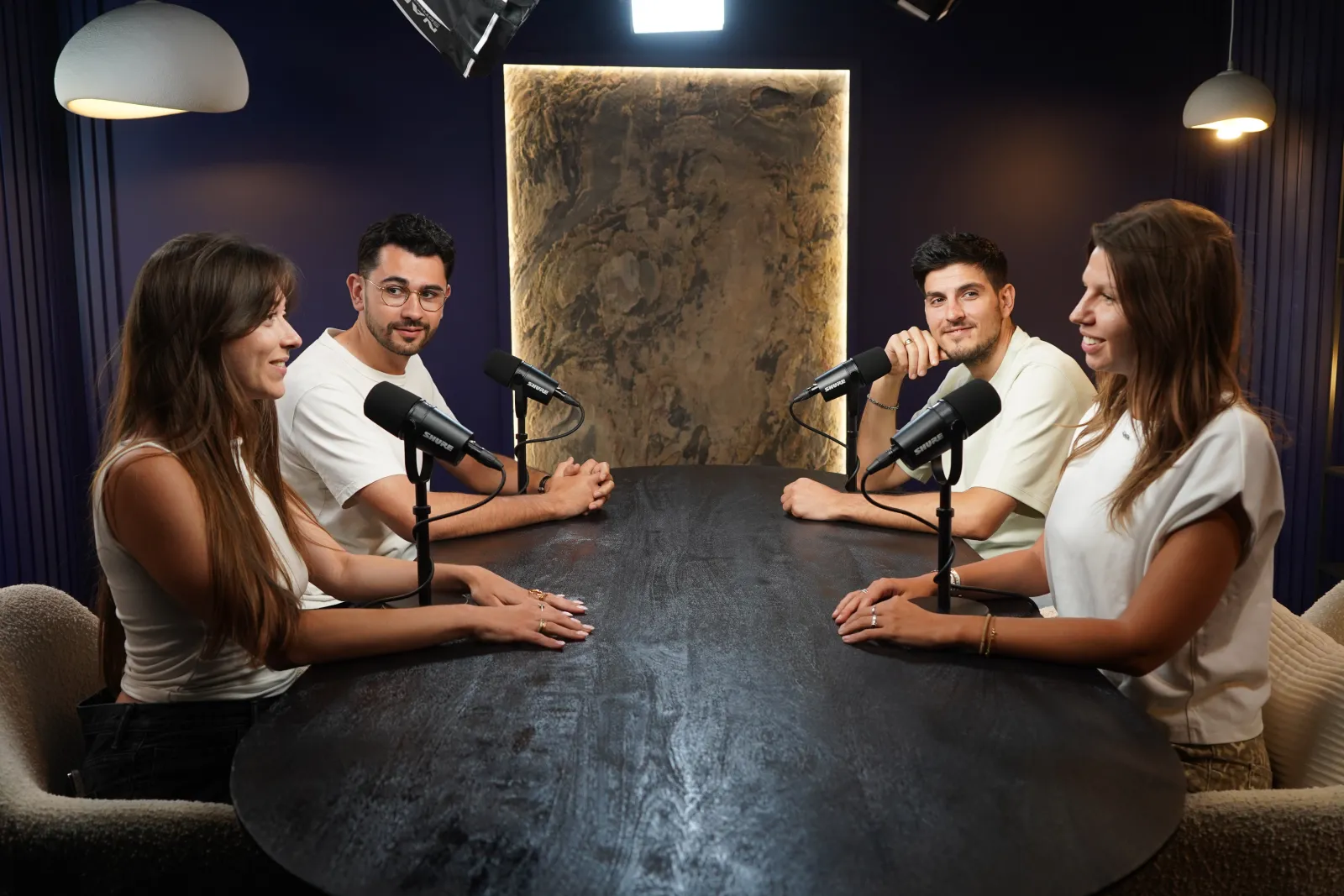 Quatre intervenants autour de la table noire du studio Galaxy