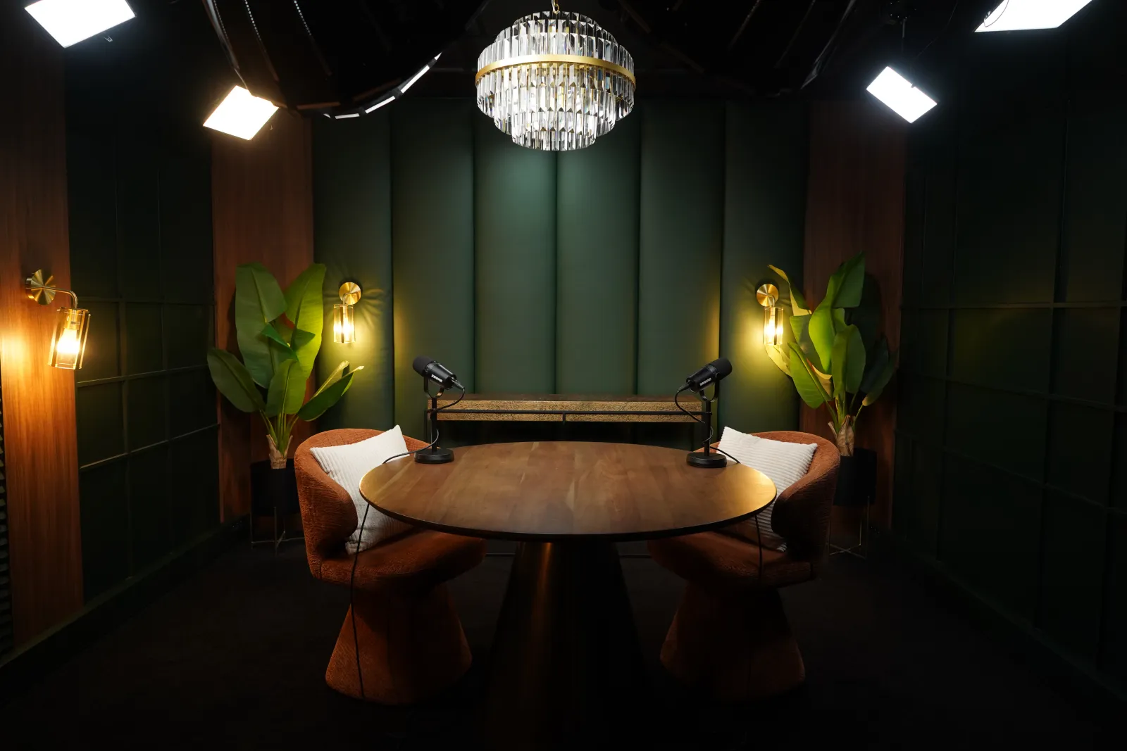 Studio Cigar Lounge de Recordia : table ronde, fauteuils cognac et boiseries vert anglais